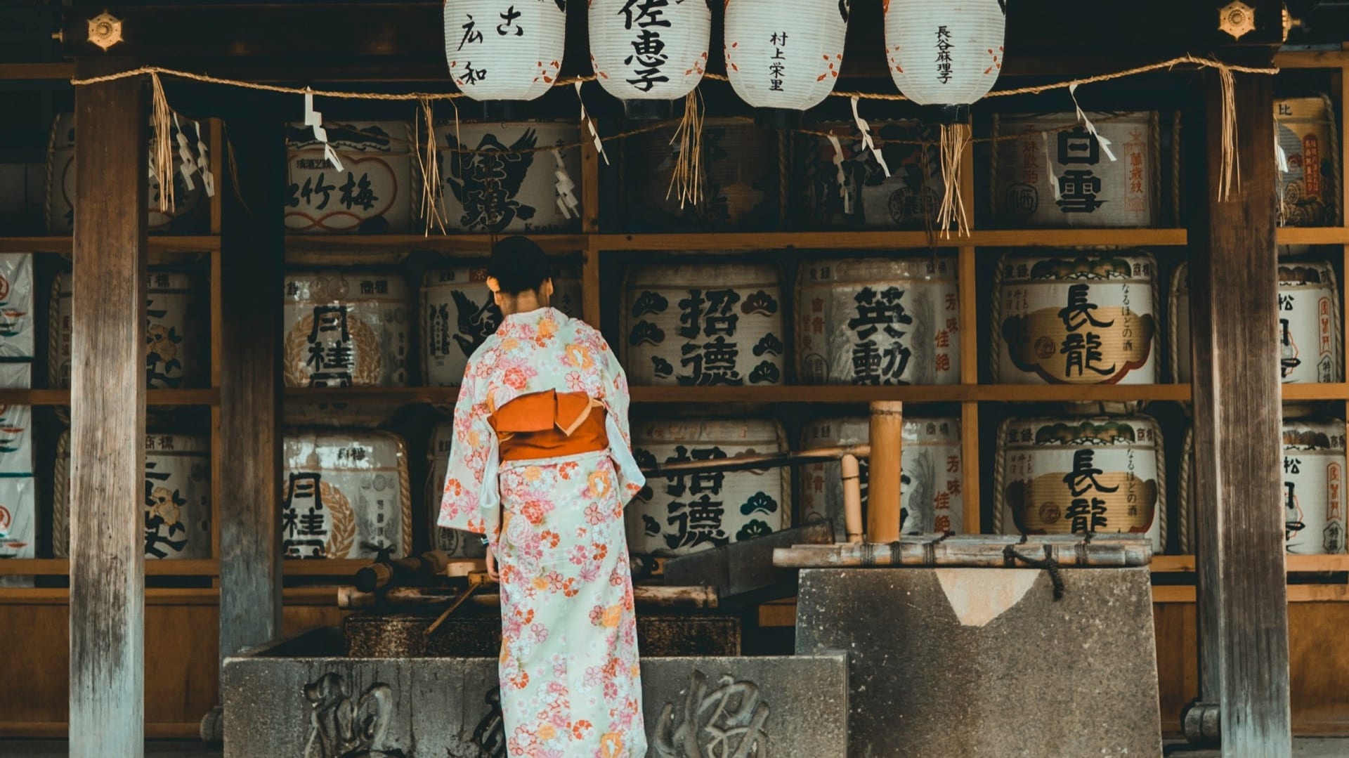 A shrine gate and lanterns glowing at night