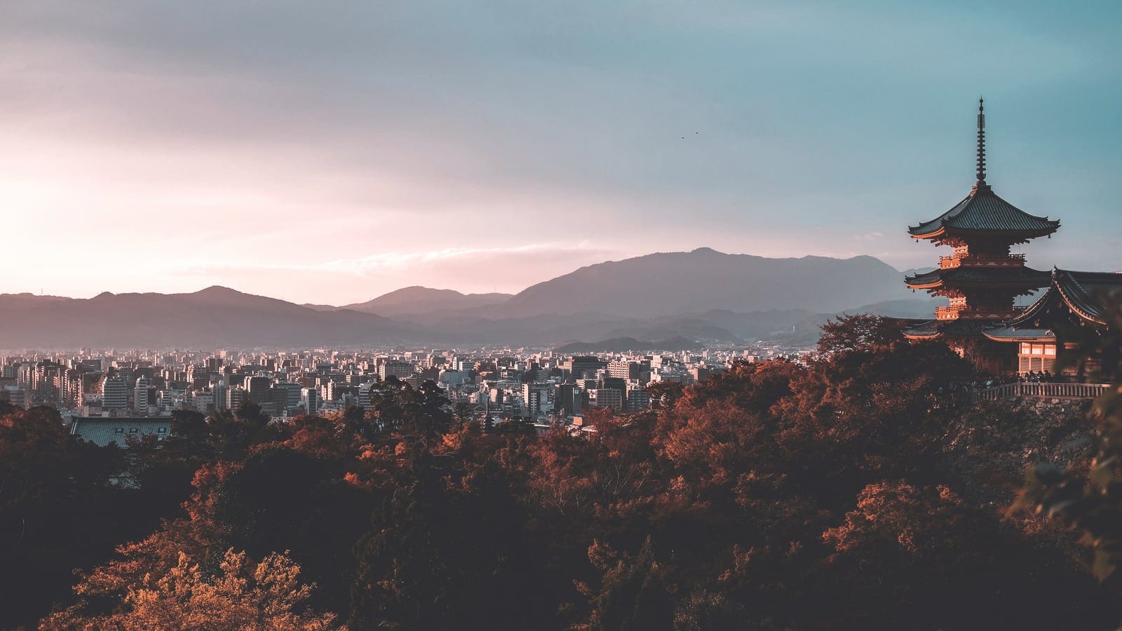 A dark pagoda silhouette overlooking Kyoto at dusk